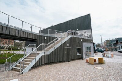 Das Bild zeigt die Treppe der Stadtwirtschaft von außen sowie einige Sitzmöglichkeiten davor.