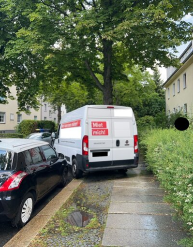 Ein weißer Transporter blockiert einen Gehweg.