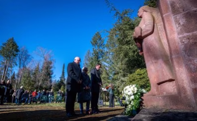 Das Bild zeigt Oberbürgermeister Sven Schulze, Zeitzeugin Eva Otto und Landtagspräsident Alexander Dierks. Sie stehen mit gesenkten Köpfen vor dem Mahnmal und gedenken den Opfern der Bombennacht.