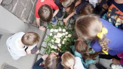 Teilnehmende der Stolpersteinverlegung legen Rosen nieder