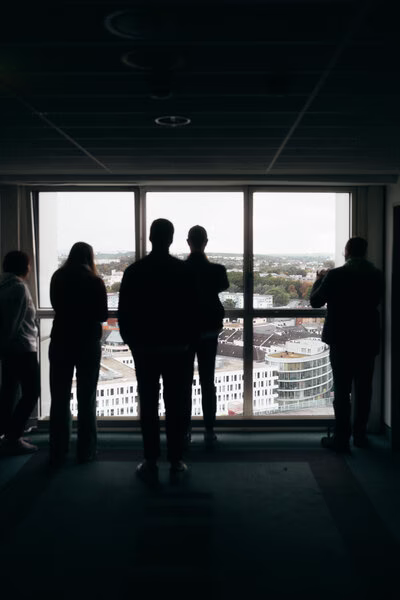 Besucher im Congresshotel Chemnitz vor bodentiefem Fenster mit Panoramablick auf die Stadt.