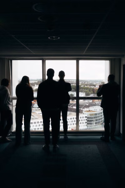 Besucher im Congresshotel Chemnitz vor bodentiefem Fenster mit Panoramablick auf die Stadt.