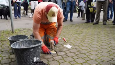 Ein Mitarbeiter des Chemnitzer Bauhofes verlegt den Stolperstein für Willy Lesser