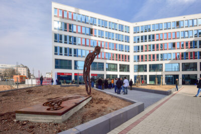 Das Neue Technische Rathaus trägt nun offiziell den Namen "Friedensplatz". Im Vordergrund die Skulptur „Reliquie Mensch“ von Michael Morgner.